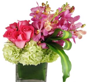 pink roses purple orchids and light green hydrangea in vase